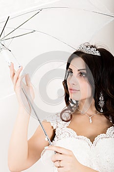 Close-up portrait of young beautiful bride in a wedding dress with a wedding makeup and hairstyle. girl holding white