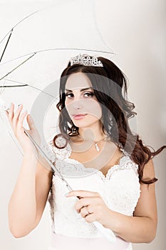 Close-up portrait of young beautiful bride in a wedding dress with a wedding makeup and hairstyle. girl holding white