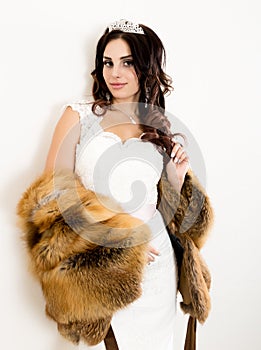 Close-up portrait of young beautiful bride in a wedding dress with a wedding makeup and hairstyle. young bride in a fur