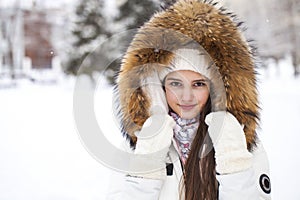Close up portrait of a young beautiful girl with a fur hood
