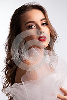 Close up portrait. Young beautiful girl with perfect make up in white veiling dress. Studio shot