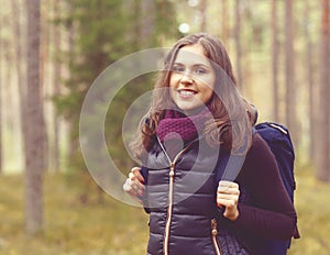 Close-up portrait of a young, beautiful and happy woman in fores