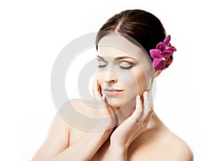 Close-up portrait of young, beautiful and healthy woman with an orchid