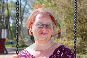 Close up portrait, Young beautiful red haired woman posing outdoors in sunny weather