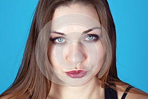 Close up portrait of young beautiful woman with light skin, dark hair and blue eyes, with smoke make up, glancing up to the camera