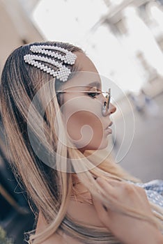 Close up portrait of a young beautiful woman with natural hairstyle. Her tresses are adorned with pearl hair clips