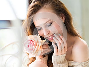 Close-up portrait of young beautiful woman smile mouth with pink rose flower and touch her face. Skin care and woman`s