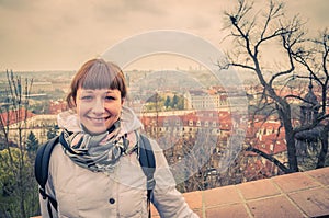 Close-up portrait of young caucasian girl traveler with white jacket looking at camera and smile