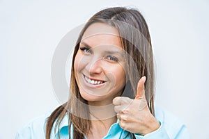 Close up portrait of young cheerful happy smiling business woman showing thumb up. Positive concept