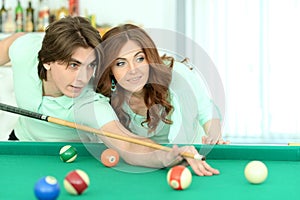 Close-up portrait of young couple playing billiard