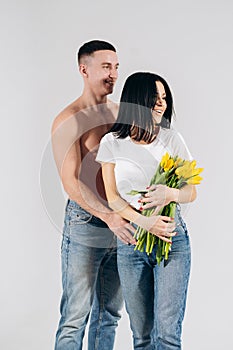 Close up portrait young couple with yellow flowers isolated on white background. lovely couple embracing with dreamy