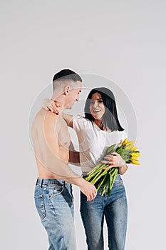 Close up portrait young couple with yellow flowers isolated on white background. lovely couple embracing with dreamy