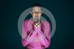 Close up portrait of young crazy scared and shocked woman isolated on dark background