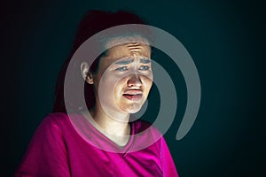 Close up portrait of young crazy scared and shocked woman isolated on dark background