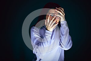 Close up portrait of young crazy scared and shocked woman isolated on dark background