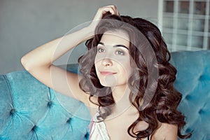 Close up portrait of a young curly girl with medium-brown hair.