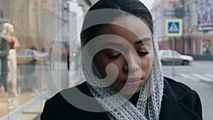 Close up portrait of young depressed black woman crying near shopping mall, no money for purchases, tracking shot