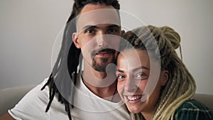 Close up portrait of the young dreadlock couple in love looking directly to the camera and smiling on the white