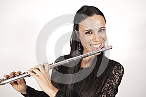 Close up portrait of a young elegant female flutist smiling with joy