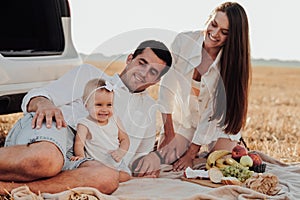Close Up Portrait of Young Family, Mother and Father with Their Toddler Daughter Having Picnic Time Outdoors During