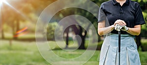 Close up portrait of Young female golf player wearing sportswear swinging on green field.Young woman golf player smiling and