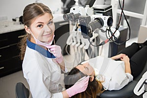 Close-up portrait of young friendly female dentist with patient in the dental office