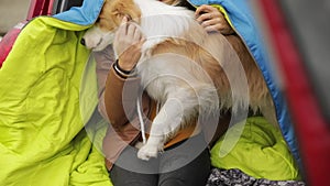 Close up portrait of young girl a woman wraps her dog in a plaid border collie sit in the trunk of a car traveling in