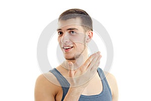 Close-up portrait of a young handsome guy who smiles and holds the Palm near the face