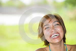 Close up portrait of young happy and beautiful expressive Asian woman laughing excited and nice in positive face expression