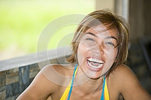 Close up portrait of young happy and beautiful expressive Asian woman laughing excited and nice in positive face expression