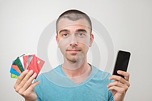 Close up portrait of young man in glasses holding a lot of gredit cards. photo