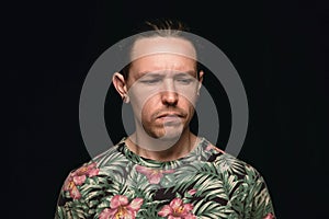 Close up portrait of young man isolated on black studio background