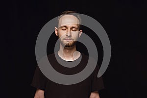 Close up portrait of young man isolated on black studio background