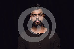 Close up portrait of young man isolated on black studio background