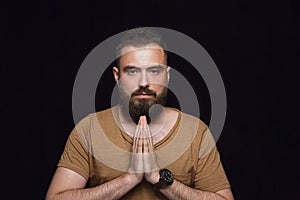 Close up portrait of young man isolated on black studio background