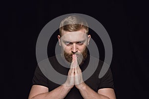 Close up portrait of young man isolated on black studio background