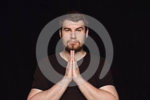 Close up portrait of young man isolated on black studio background