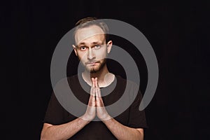 Close up portrait of young man isolated on black studio background