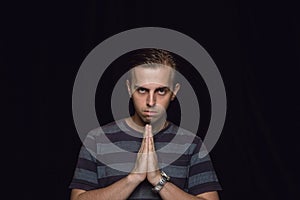 Close up portrait of young man isolated on black studio background