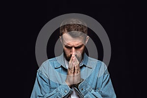 Close up portrait of young man isolated on black studio background