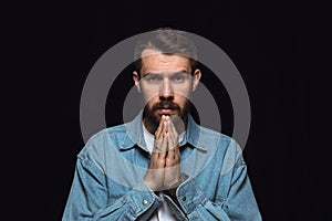 Close up portrait of young man isolated on black studio background