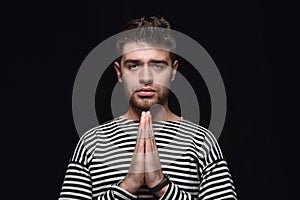 Close up portrait of young man isolated on black studio background