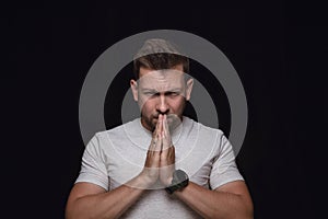 Close up portrait of young man isolated on black studio background