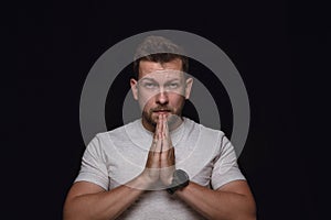 Close up portrait of young man isolated on black studio background