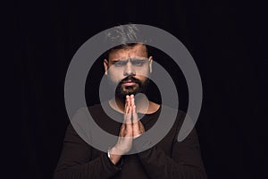 Close up portrait of young man isolated on black studio background