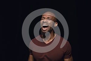 Close up portrait of young man isolated on black studio background