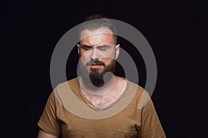 Close up portrait of young man isolated on black studio background