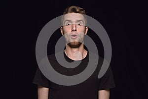 Close up portrait of young man isolated on black studio background