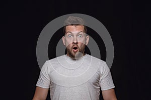 Close up portrait of young man isolated on black studio background