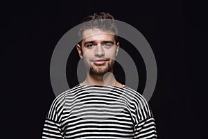 Close up portrait of young man isolated on black studio background